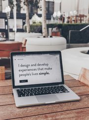 A website on a laptop screen outside on a bench